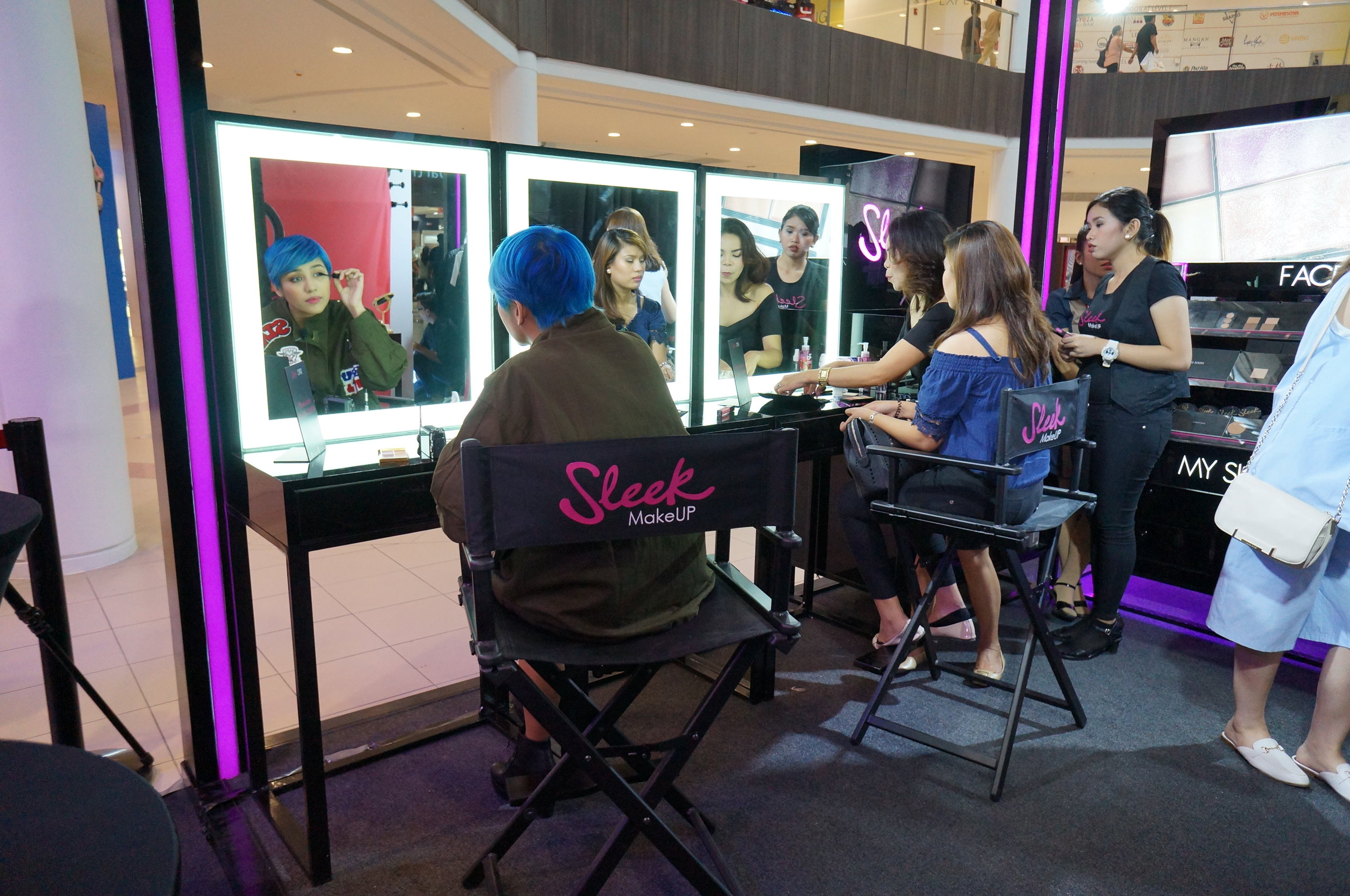 Sleek muse Jessica Godinez (left) tries out Sleek cosmetics on herself, while another guest (right) is assisted by a Sleek consultant