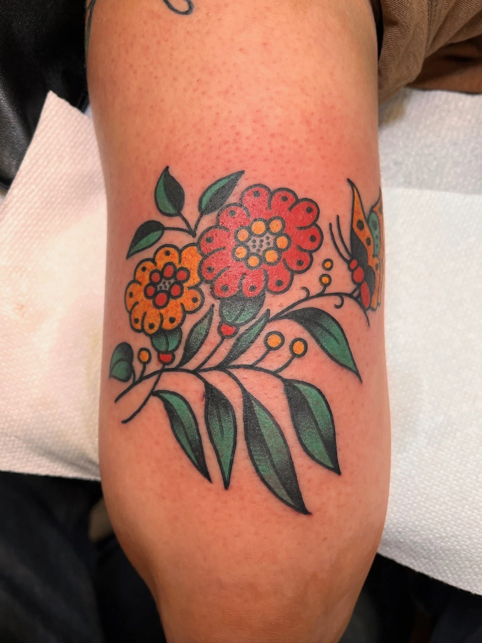 traditional-floral-branch-orange-yellow-tattoo-arm.jpg