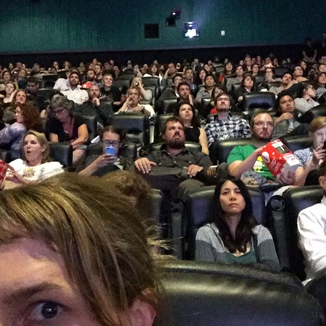 A surprising lot of people sitting in a movie theatre in order to listen to podcasts. by amystanden
