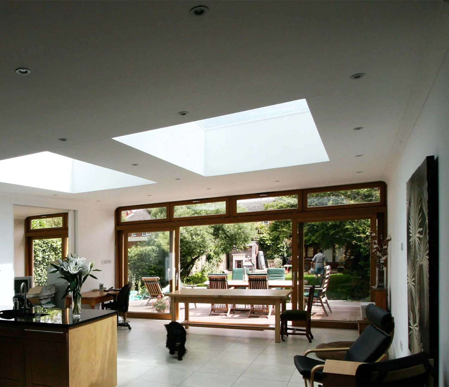HARTSWOOD ROAD This Full width extension of a semi-detached family house in west London provides a new kitchen/dining room for the family and a den for the dad to disappear into. Large sliding doors were installed between the two rooms, flexibility between the two rooms. Large elevated roof lights were placed across both spaces to bring direct sunlight in, but to make the space feel higher as the ceiling height achievable was restricted existing levels in the house. Full width glazed door were installed across the entire rear wall to connect the new space with the garden. 