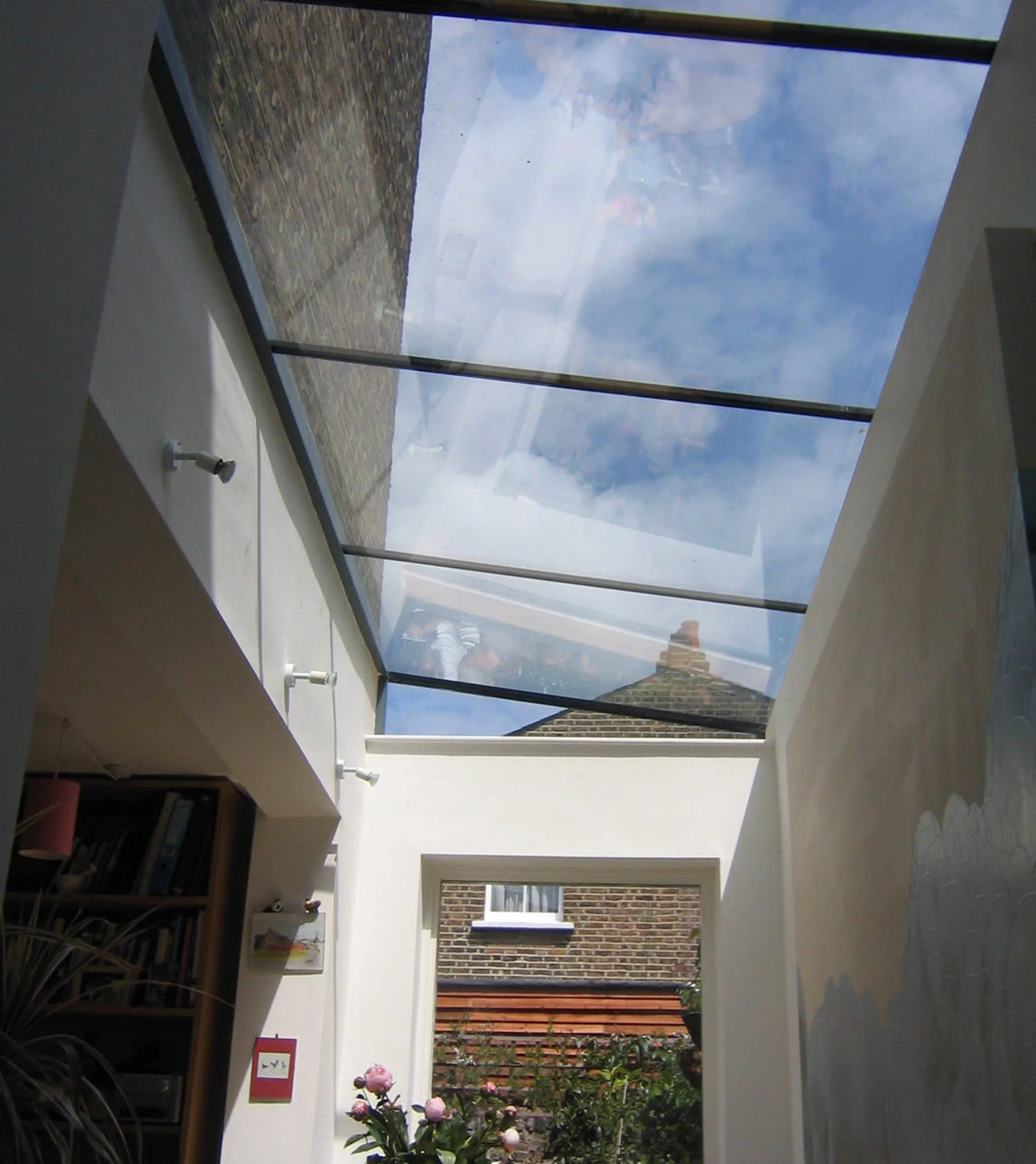 HAYDEN PARK ROAD The ground floor of a Victorian house was converted into a one bedroom flat and extended into an unused area of the garden. Using discrete yet modern frameless glass, and a picture window at the end of the space, light and space and views were brought into this previously dark and narrow apartment.