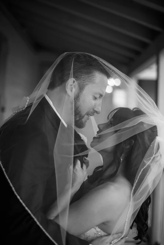 a bride and groom hide from the rain on the balcony at the White Room's Villa Blanca