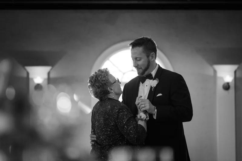 a groom dances with his mother in the ball room at the White Room