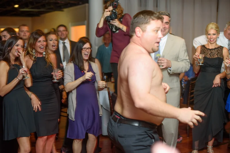 a guest loses his shirt and dances at a reception at the White Room in St. Augustine, Florida