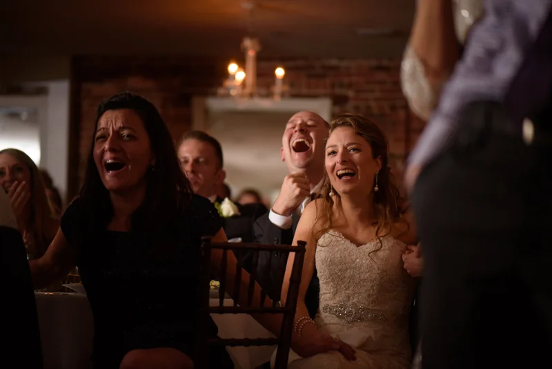 a bride and groom laugh during their toasts during their reception at the White Room in St. Augustine, Florida