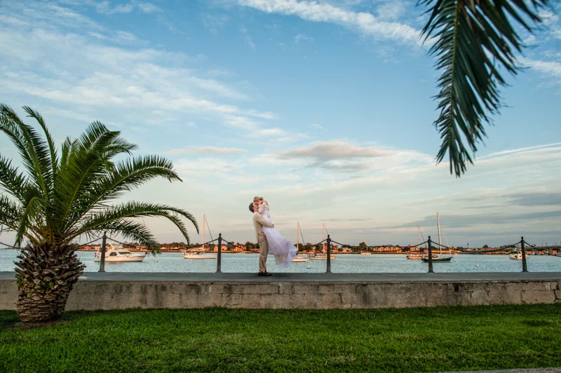 grooms lifts bride off of her feet on the bayfront at the White Room in St. Augustine, Florida