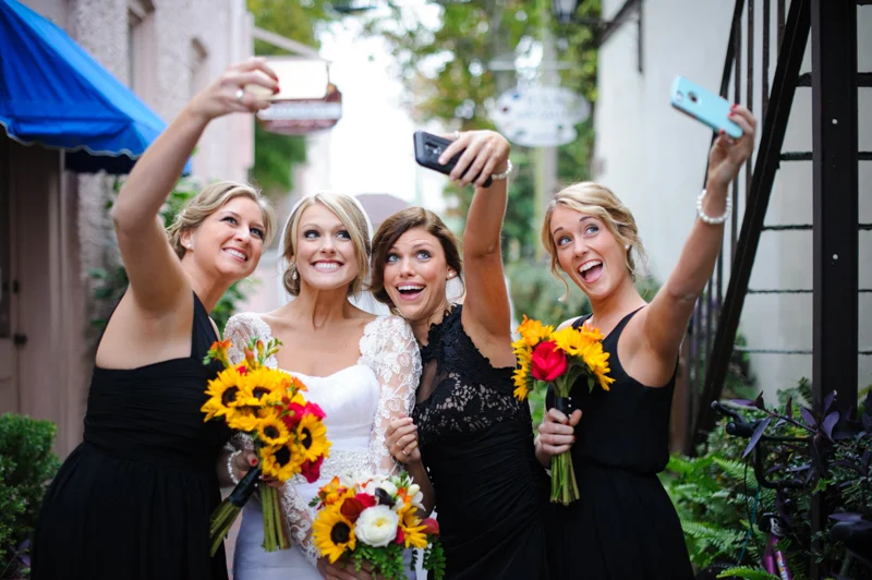 bride takes a selfie with her bridesmaid just downstairs from the White Room in St. Augustine, Florida