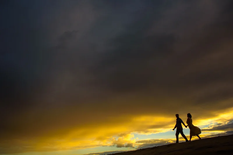 Heather and Greg walking on the beach at sunset in Vilano Beach.