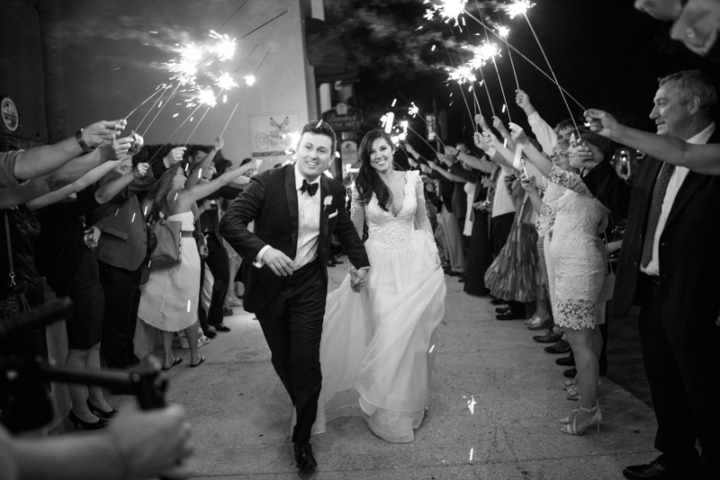 bride and groom sprint to their get away car at their late night sparkler exit