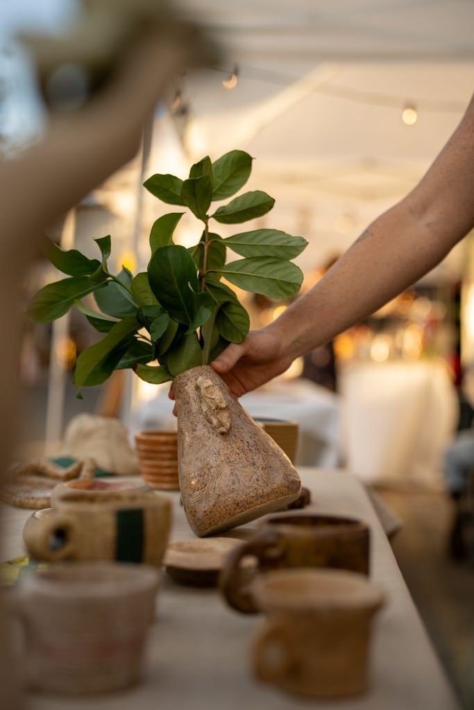 Hand holding rustic vase with leaves.jpg