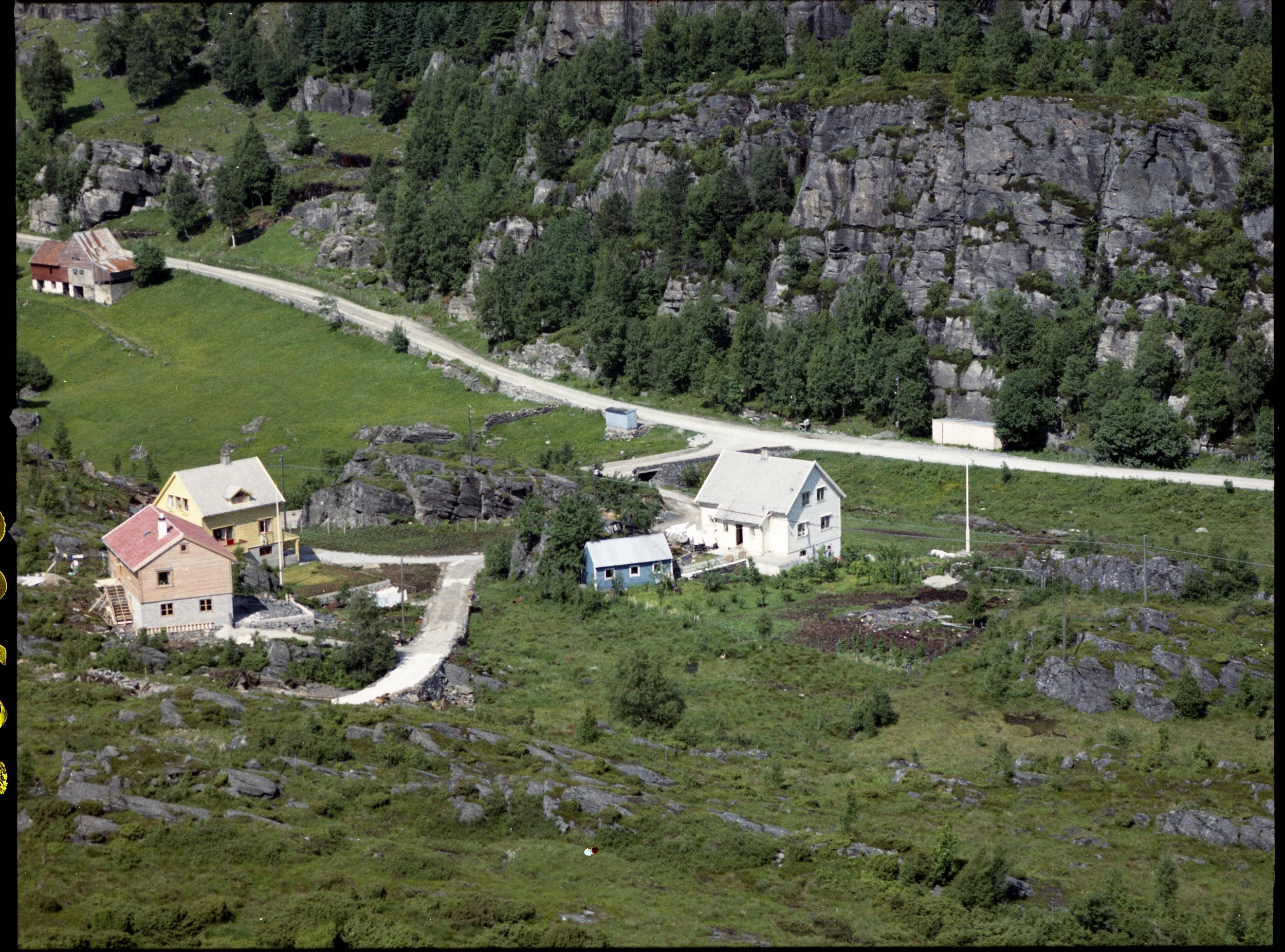Litt mer om dette bildet som AV presenterte: Det var i kjelleren i huset i midten (tilhørende Bergfjord) at Sigmund Juvik startet opp en dagligvarehandel i 1952. I 1972 bygde han et nytt forretningsbygg i området til høyre i bildet. Dette bygget har huset div. butikker opp gjennom årene, og er blitt utvidet flere ganger. I dag huser det Janco Expert og BOA sykler. Den store fjellknausen mellom husene ble sprengt vekk da det ble bygget en bensinstasjon der Bergfjords hus står, samtidig som veien ble lagt om. I disse dager fjernes også bensinstasjonen slik at det kan bygges et nytt forretningsbygg på denne tomten.