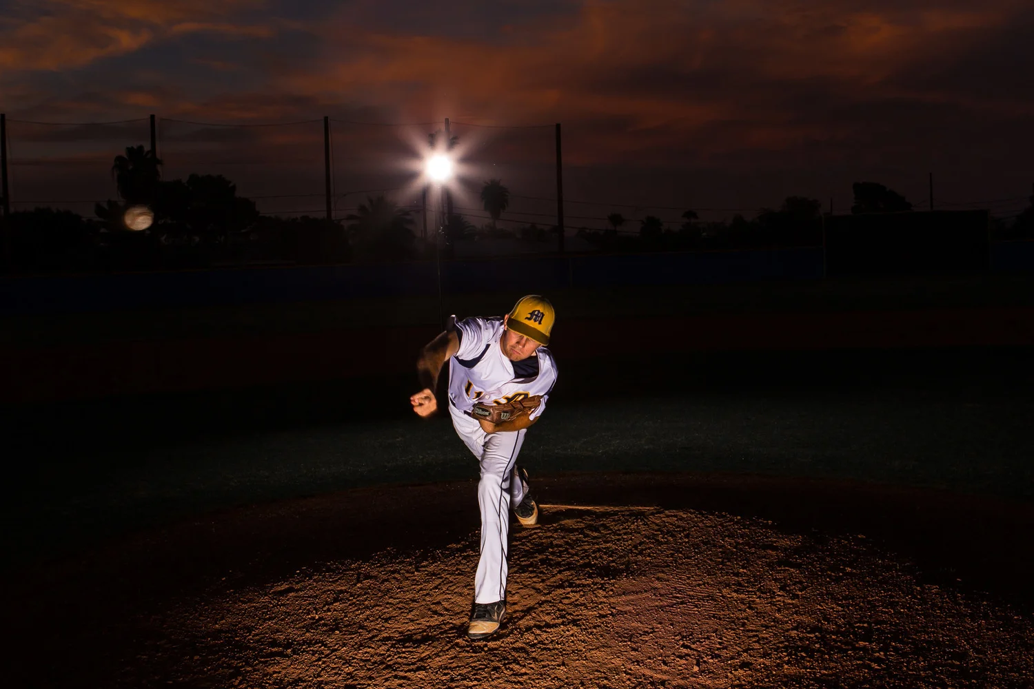 Trevor was a three year varsity pitcher and has great throwing mechanics. This image was taken after sunset and it was nearly dark. I love the dramatic skies Arizona sunsets can create. I used two alien bee strobes to create this image and freeze the motion. It took quite a few attempts to get the ball in the shot but eventually we got it!