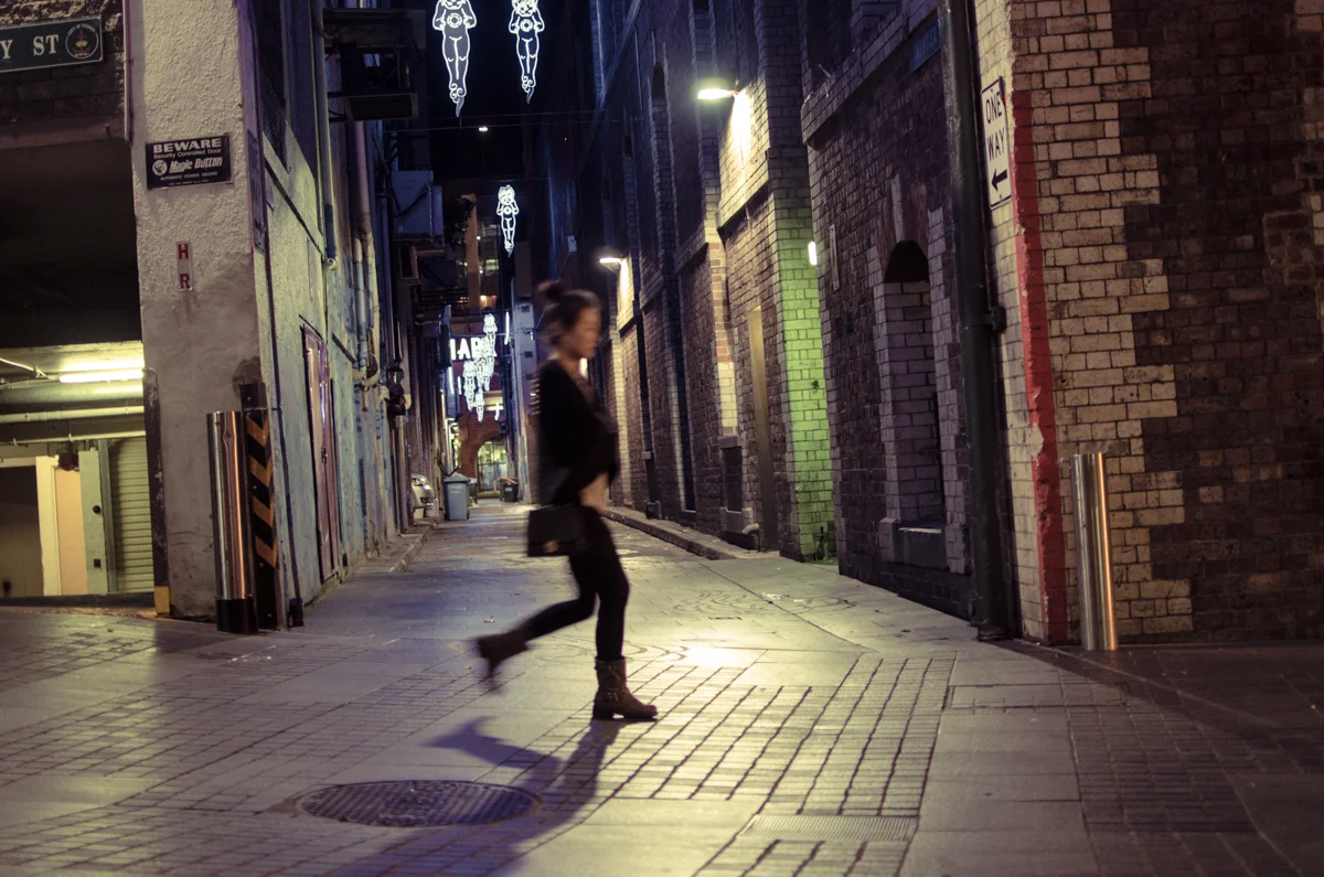 A woman walks through
the safe yet unsettling city streets after another day's work.