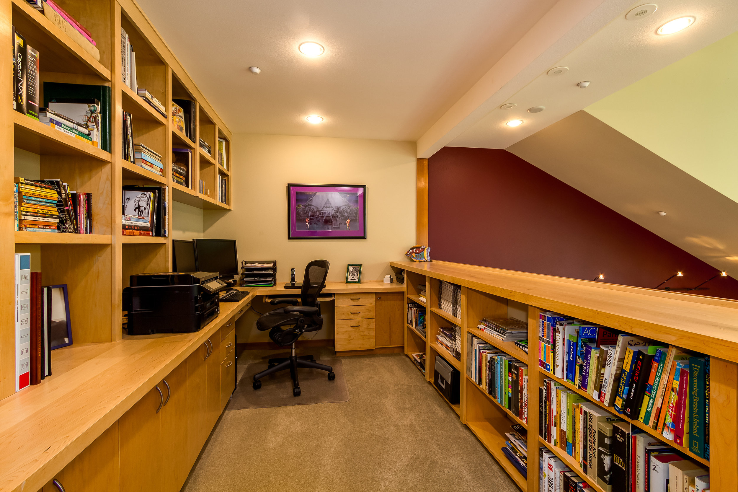 Overlooking the downstairs, this upstairs loft area is packed with endless custom shelving and cabinets. 
