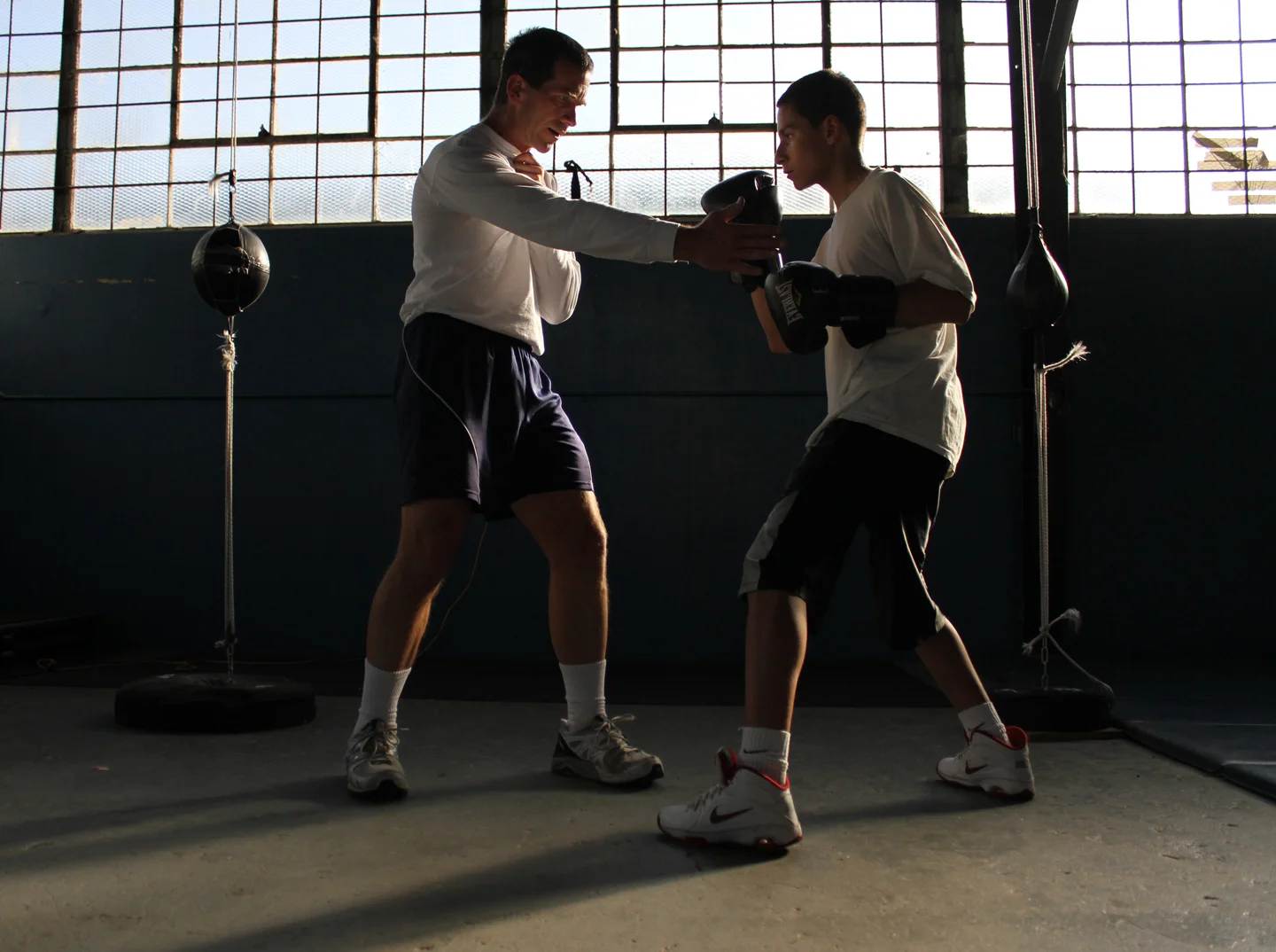 Coach Dan Robinson helps Marcos Callazo, 14, learn which parts of the body to punch.