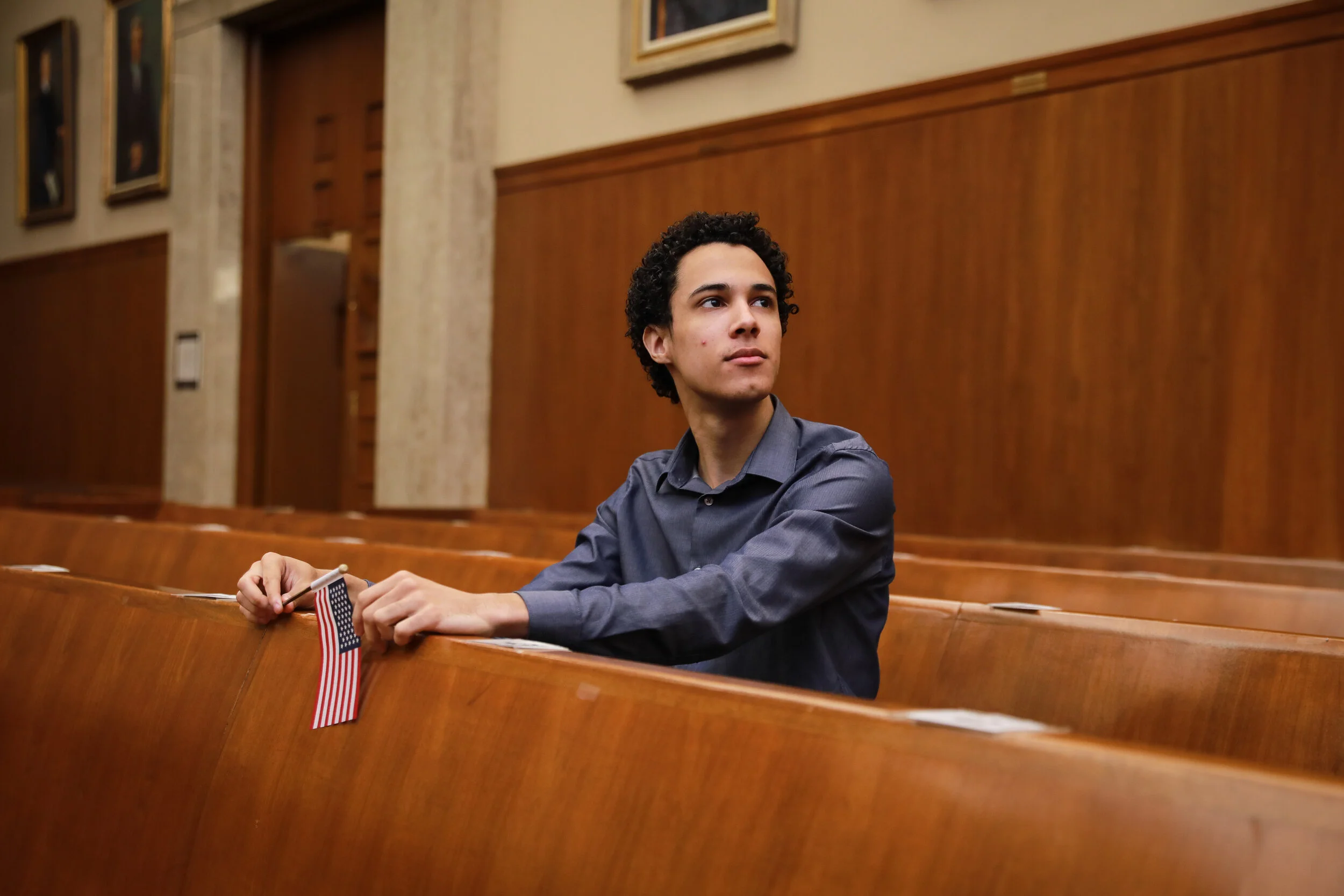  Christopher Cameron pauses for a portrait in the courtroom where he was sworn in after his naturalization ceremony. (Amanda Andrade-Rhoades for The New York Times) 