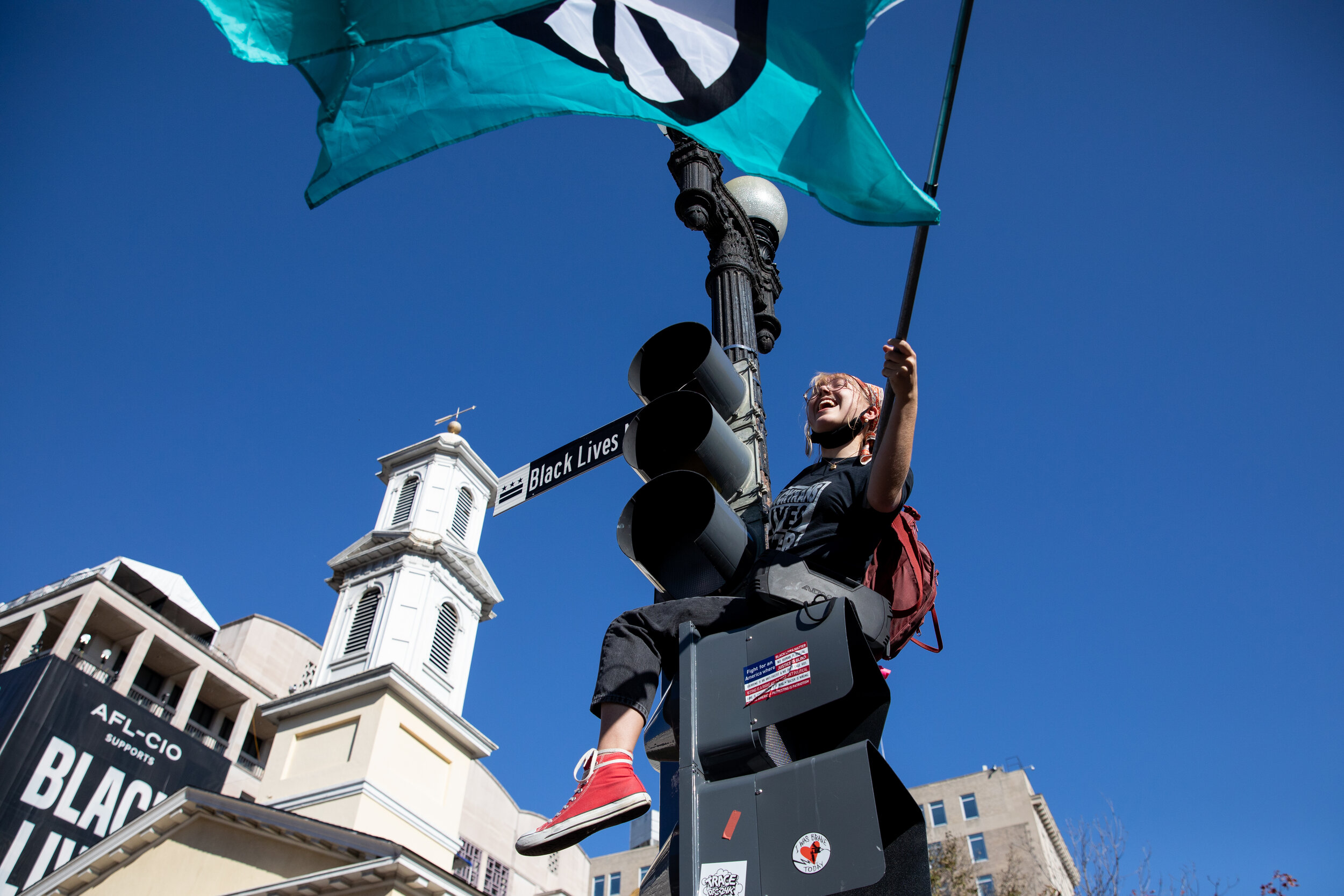  A woman waves a flag bearing a peace sign while celebrating the news that Joe Biden has won the U.S. presidency outside of the White House in Washington, D.C., US, on Saturday, November 7, 2020. (Photo made for Hufvudstadsbladet) 