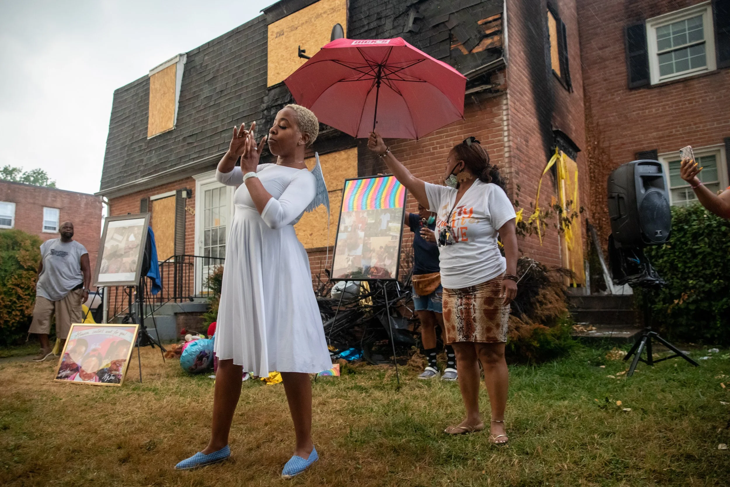  Praise dancer Kendra Mosley performs during a memorial for sisters Jayla Brown, 9, NyJae Meade, 6, and NaJhari Meade, 1, outside of their home in Hillcrest Heights, Maryland, where the girls were killed in a fire a week prior, on Monday, July 26, 20