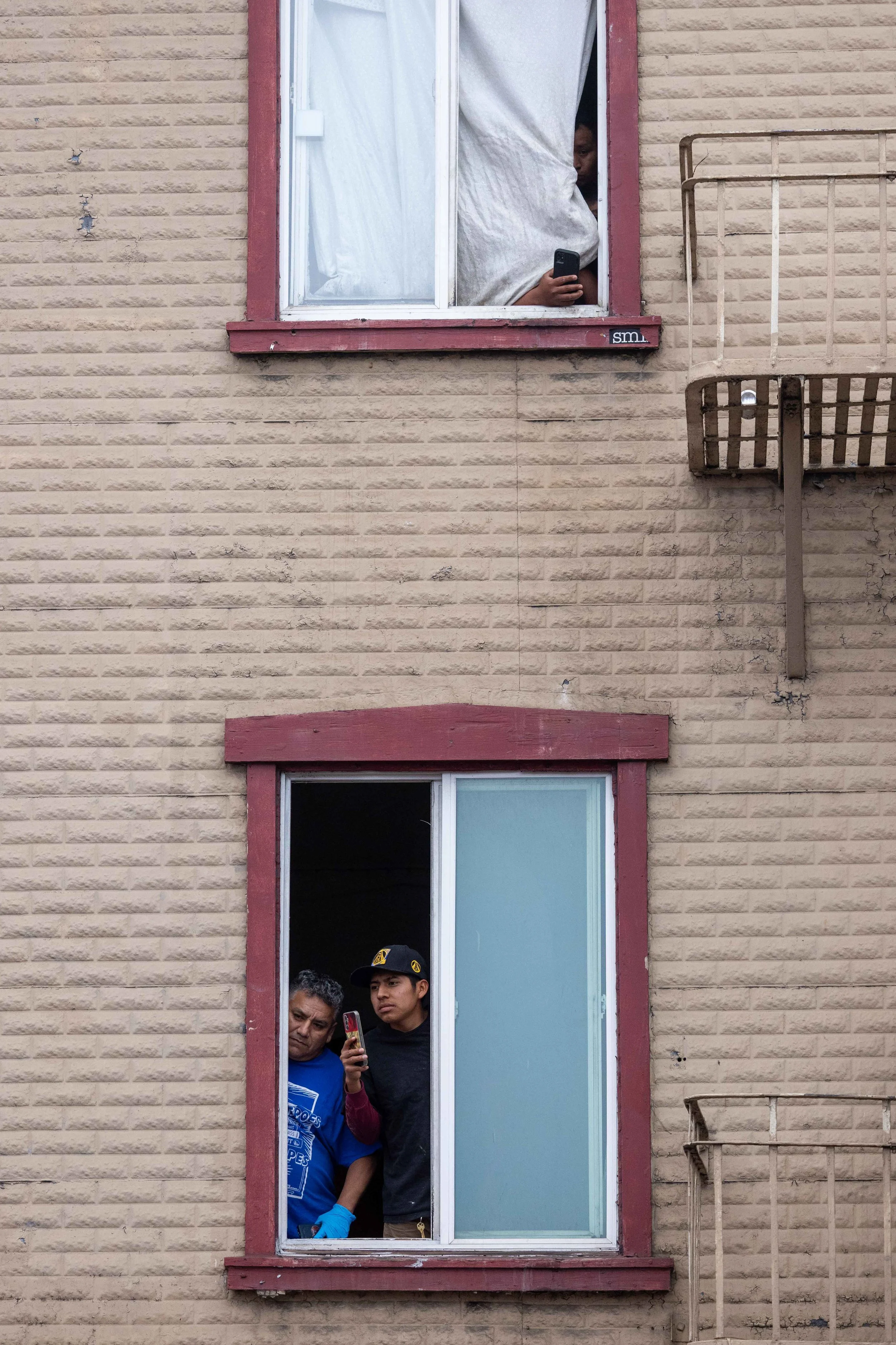 People watch demonstrators during a protest against Immigration and Customs Enforcement (ICE) raids at 24th and Mission in San Francisco on Monday June 9, 2025. (Amanda Andrade-Rhoades/The San Francisco Standard)