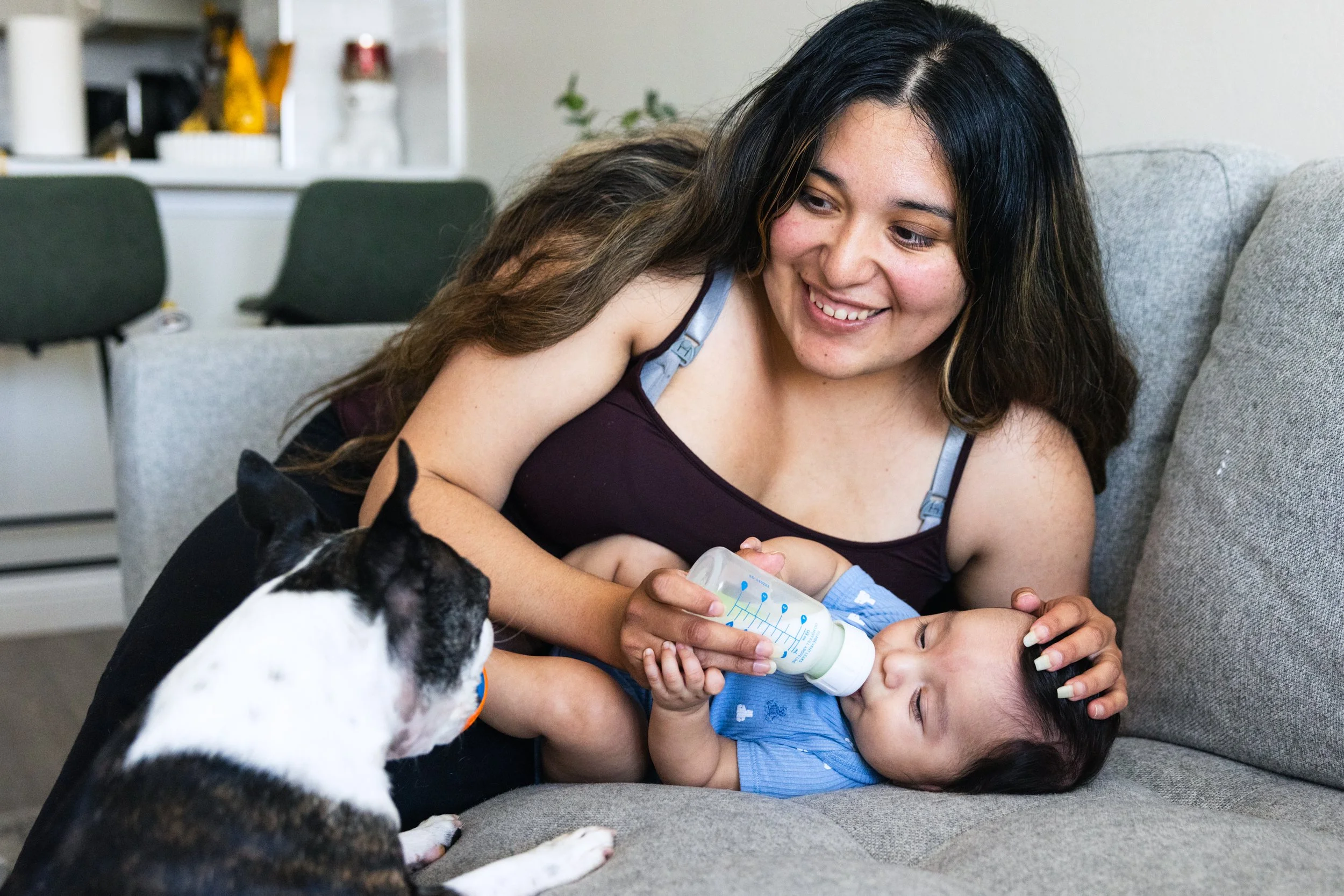 Magali Hernandez feeds her son Franco Ramirez as her dog Baxter looks on at her home in San Francisco on September 24, 2024. (Amanda Andrade-Rhoades/The San Francisco Standard)