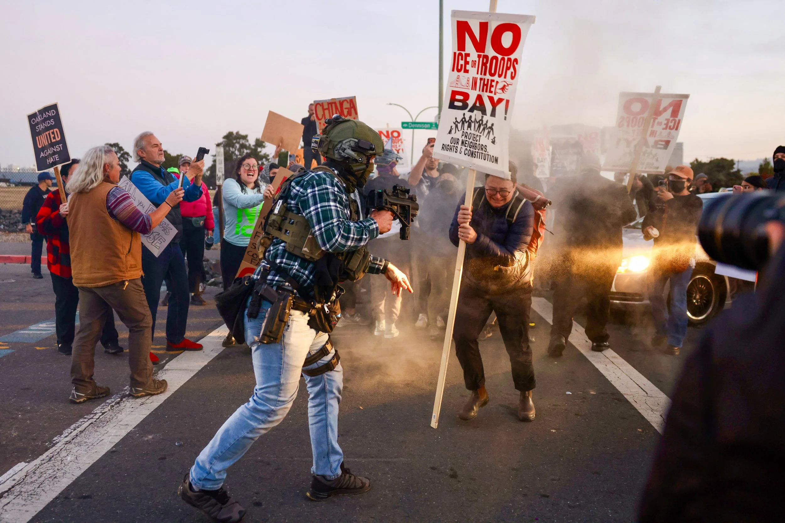  A border patrol agent pushes a demonstrator after detonating a flash bang grenade near the entrance of Coast Guard Island in Alameda on Thursday, October 23, 2025. (Amanda Andrade-Rhoades/The San Francisco Standard) 