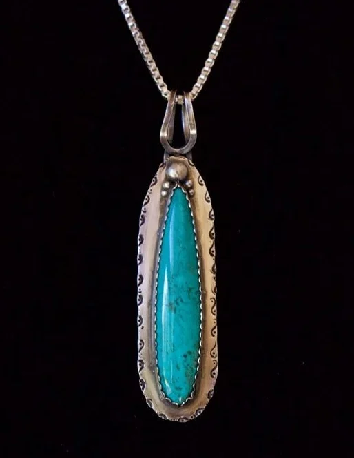 The Wonder Of It All" Pendant – classic with a little Southwest Twist featuring a gorgeous Kingman Turquoise stone cut by Jason Brousseau, NM and set in sterling silver elicited the following from Fronnie Bealer ~ “You are walking along in the desert leaving some footprint (the little scrolls on the sides) when you serendipitously come upon a narrow lake, which offers refreshment for body and soul. I love the splash of turquoise.”