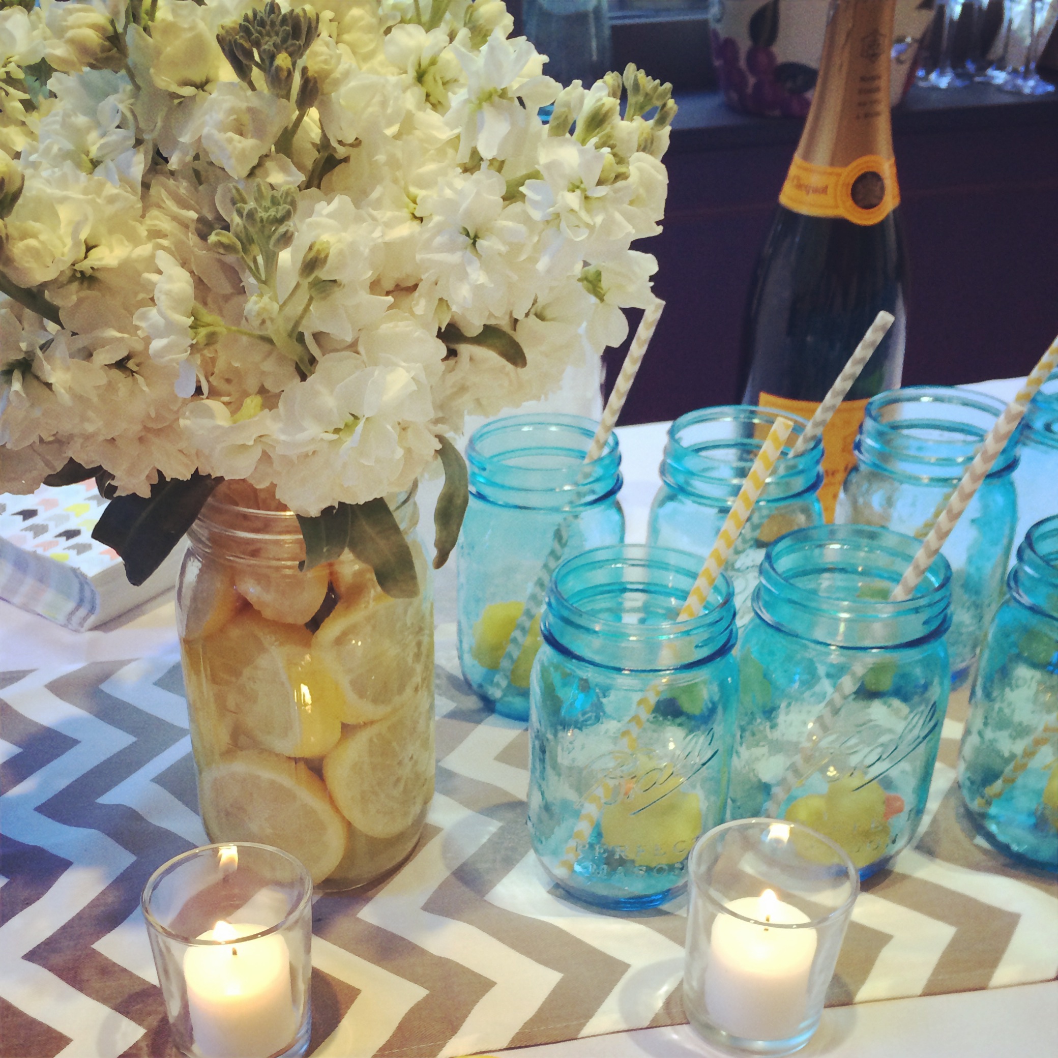 Arrangements of white stock flowers and mason jars with striped straws and rubber ducks adorned the bar
