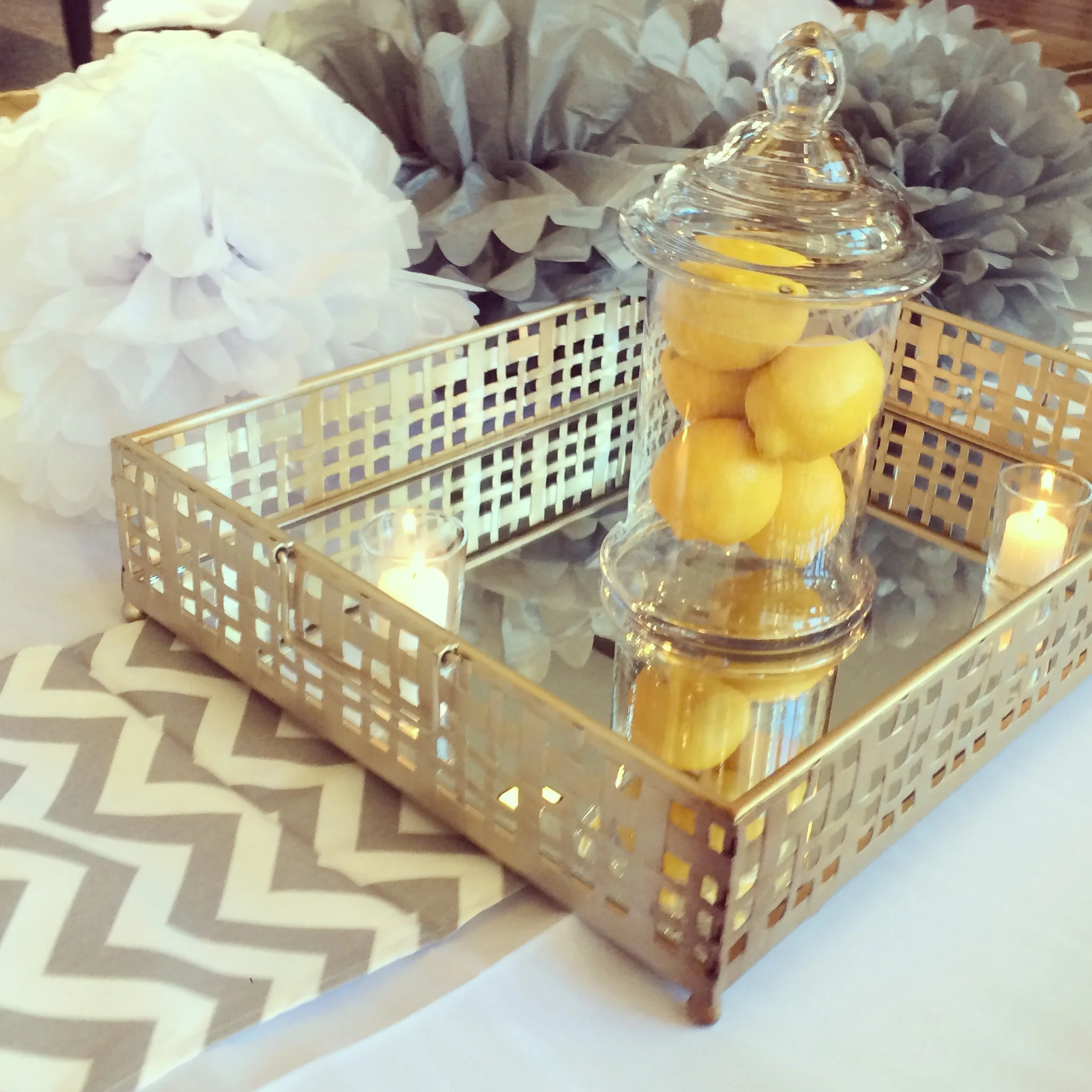 Mirrored trays with lemon-filled glass jars and votive candles
