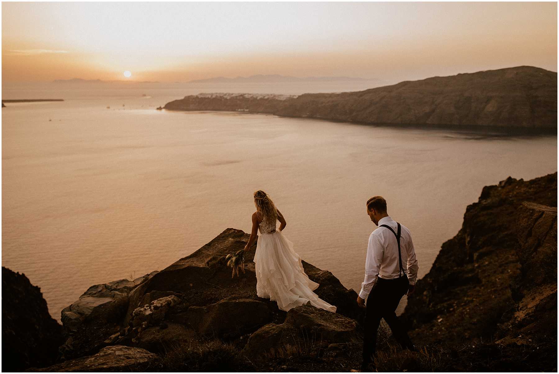 A couple adventuring at sunset after their wedding in Santorini
