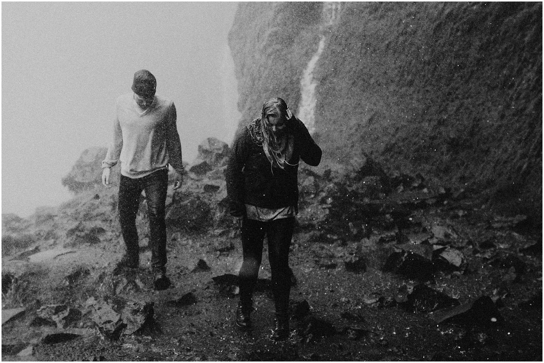 An adventurous couple soaked in a waterfall in Iceland