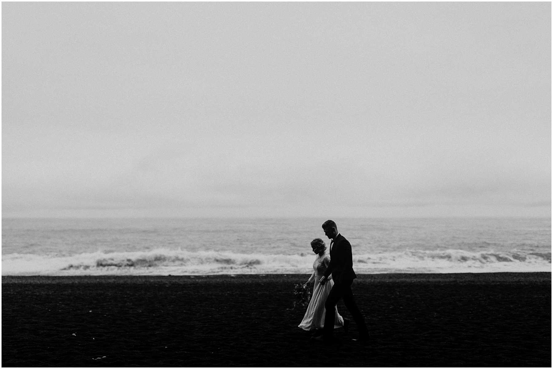 A bride and groom at Black Sands Beach in Vik, Iceland