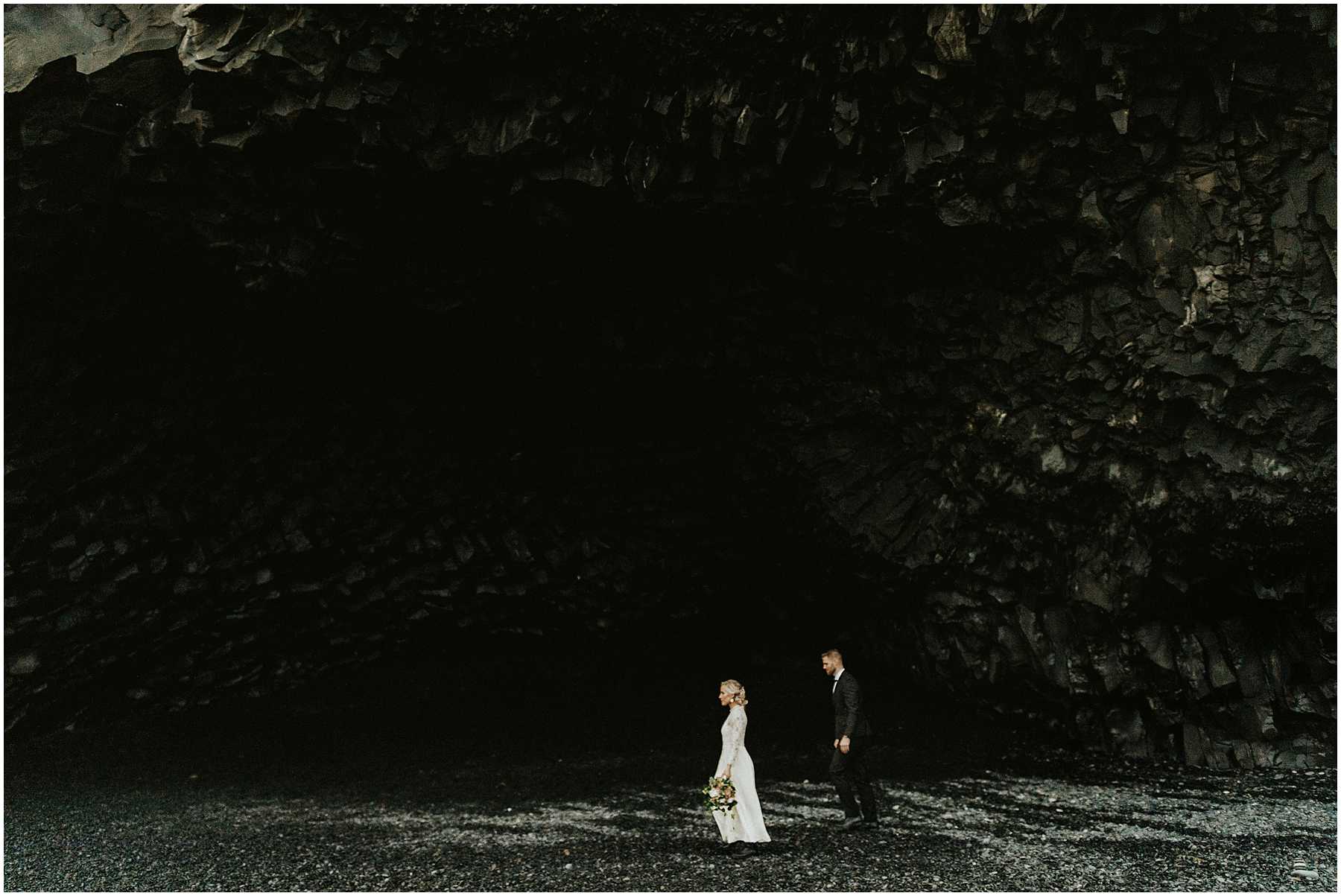 A bride and groom at Black Sands Beach in Vik, Iceland