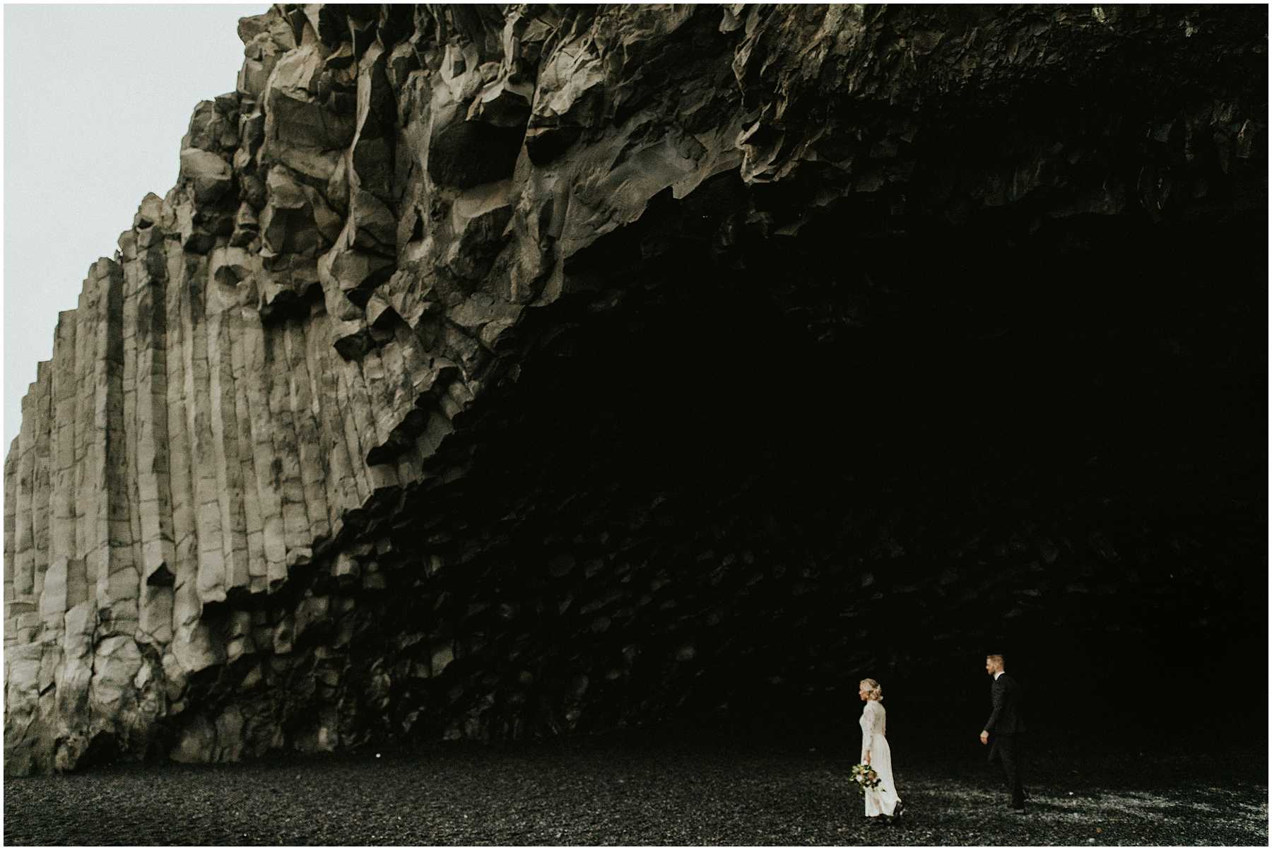 A bride and groom at Black Sands Beach in Vik, Iceland