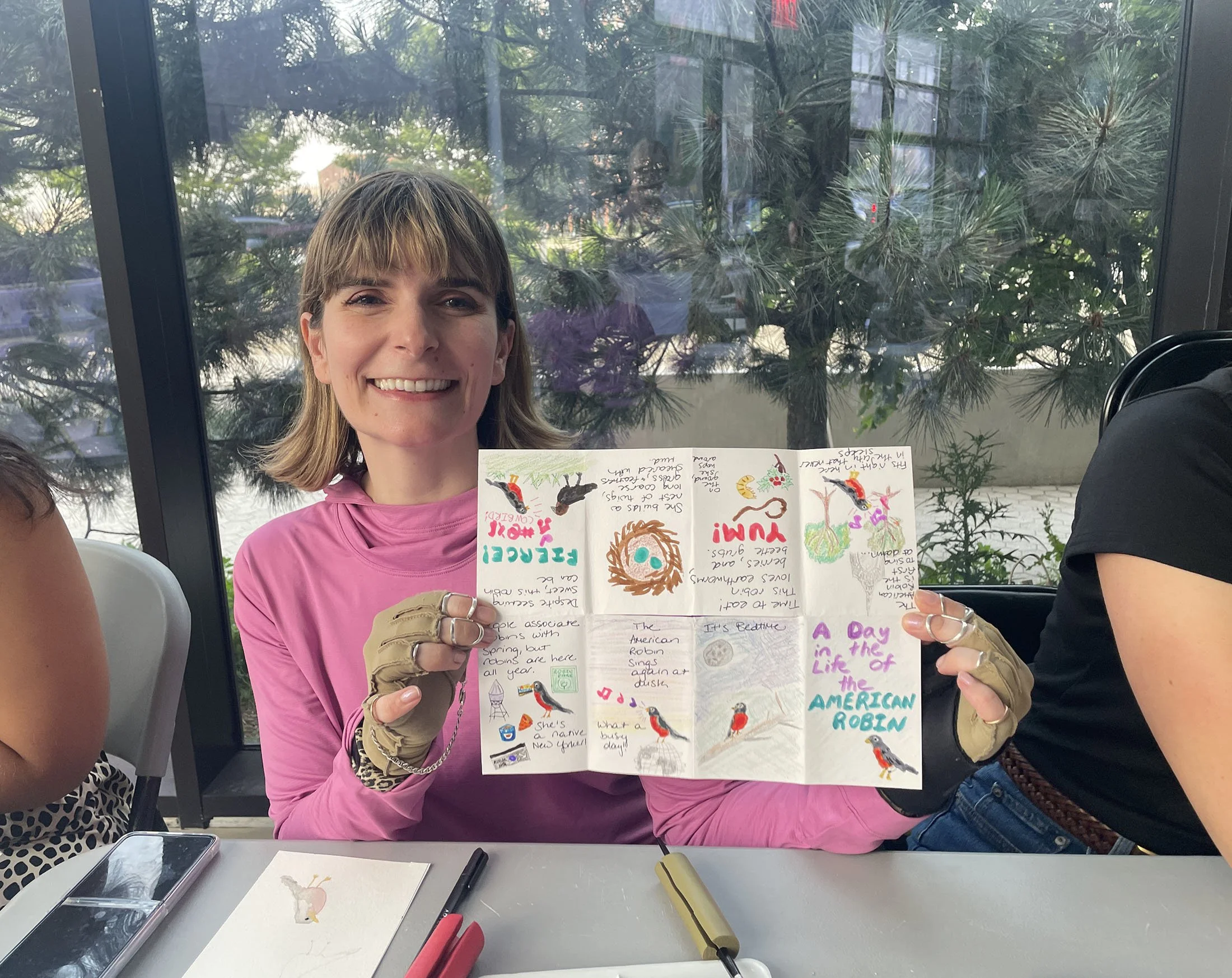 Student holding their bird migration zine