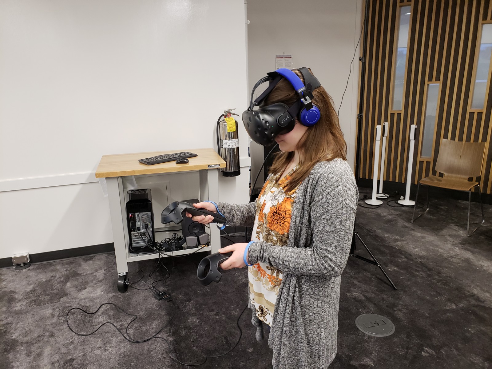 The full HTC Vive hehadset and controllers, which the author wears here, provides a fully immersive VR experience, but costs much more. Photo Credit: Alyssa Wroblewski