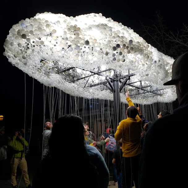 The CLOUD installation at nighttime with viewers pulling on select light switches. Photo Credit: Alyssa Wroblewski