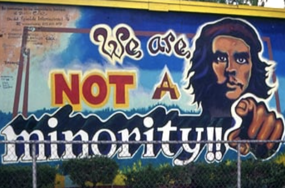 Mural with the words "we are not a minority" and man pointing to viewer