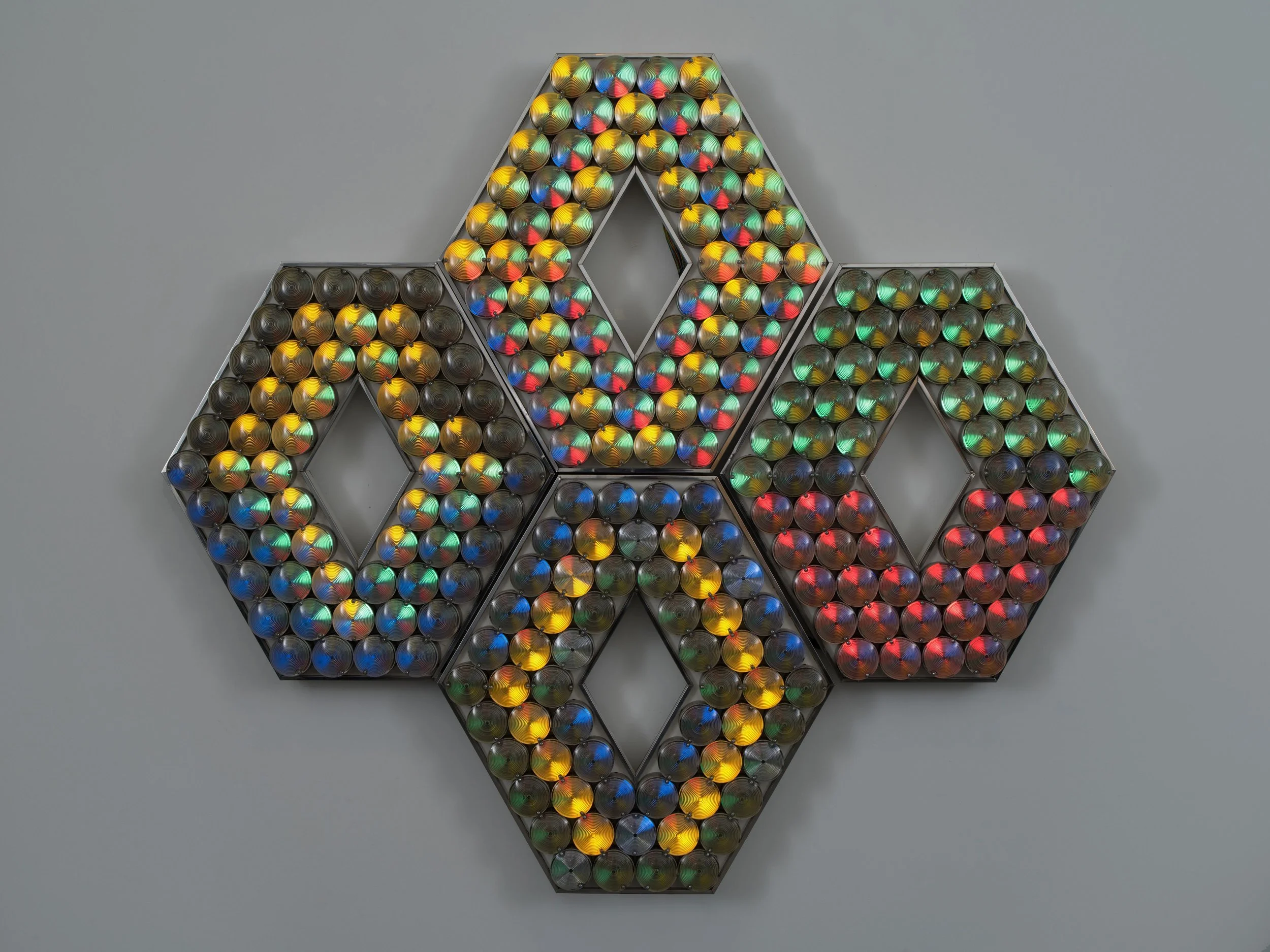 Polygonal light sculpture with 13 sides and range of warm and cool colors.