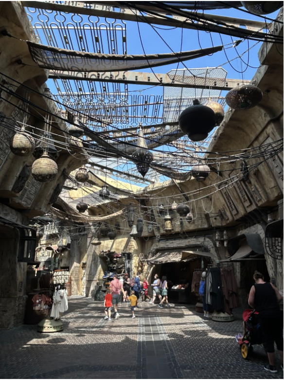 Outdoor themed environment with sci-fi architecture and visitors walking through Galaxy’s Edge.