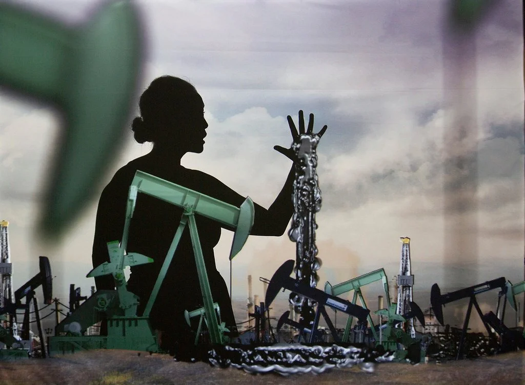 Image of black figure with sliver liquid pouring out of hands, and surrounded by oil rigs in foreground and background
