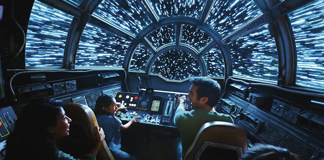 Visitors interacting with immersive themed environment featuring lights, props, and digital elements.