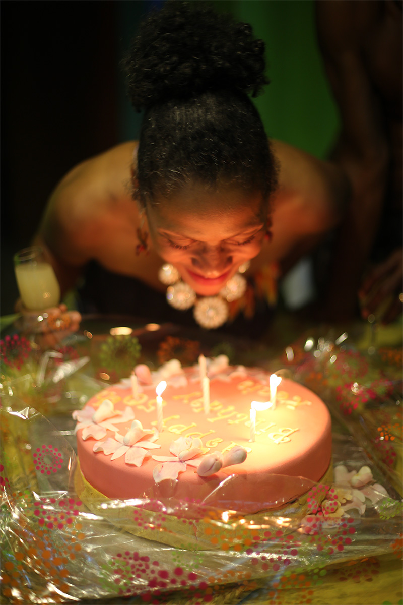 Blowing out the candles on my birthday cake with a glass of sea moss in my hand.