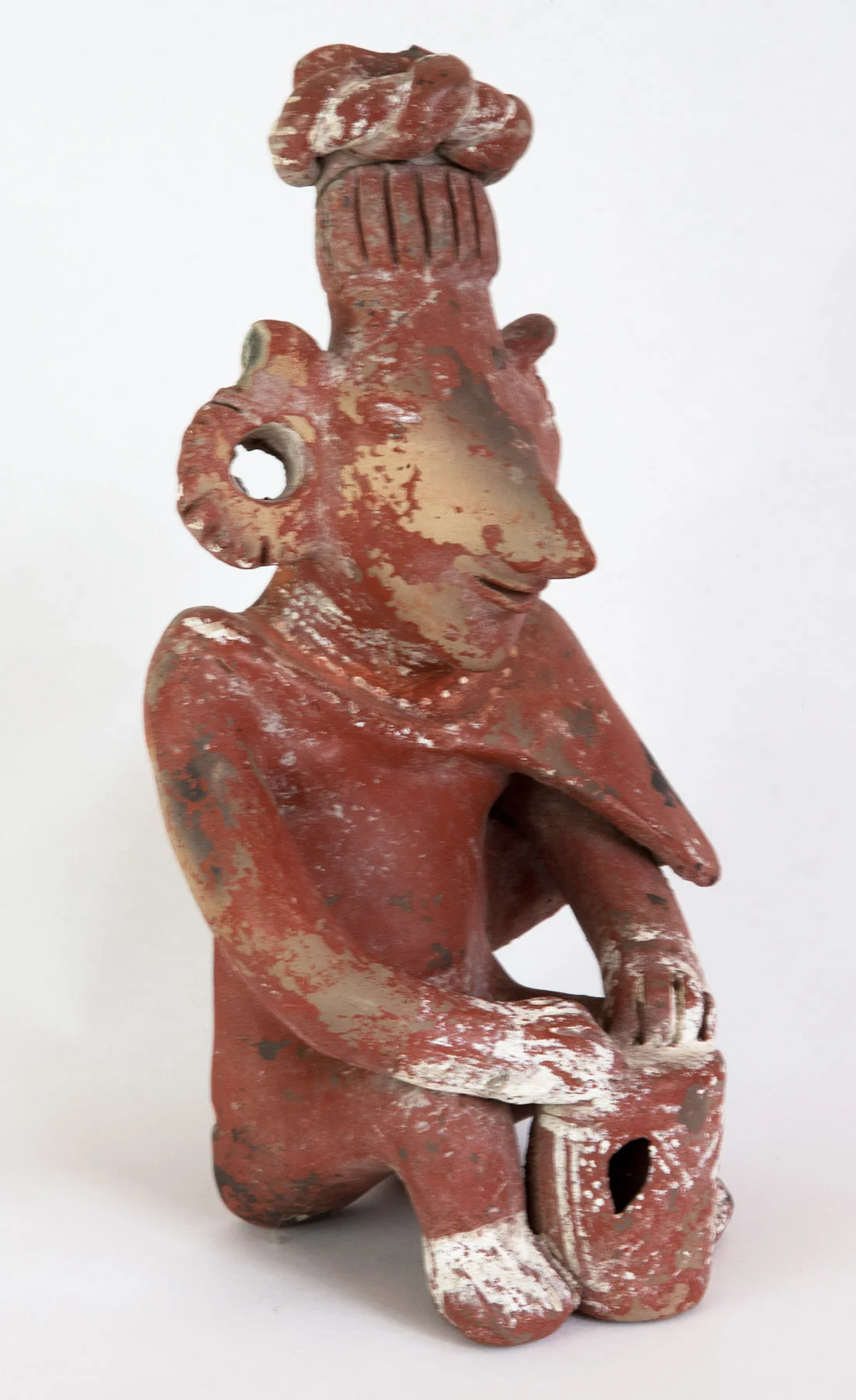 Jalisco seated figure ("Sheep face") playing a drum. Some surface damage on face. 200 BC-200 AD 10-1/2" high.
