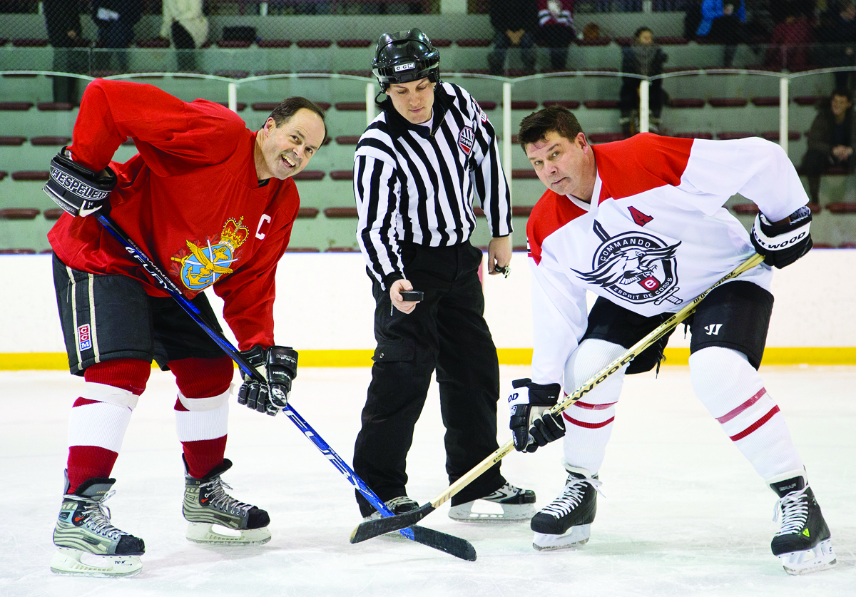 Facing off for Canadian military members and their families: GOFO captain Gen. Tom Lawson, left, and Esprit de Corps publisher Scott Taylor, Captain of the Commandos, ready for the puck to drop in the January 2014 game.