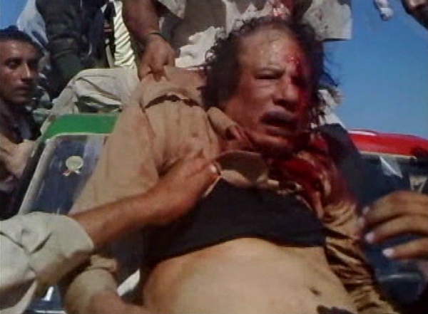 Moammar Gadhafi being dragged through the streets, where he was eventually beaten and shot to death. (Wikimedia photo). 