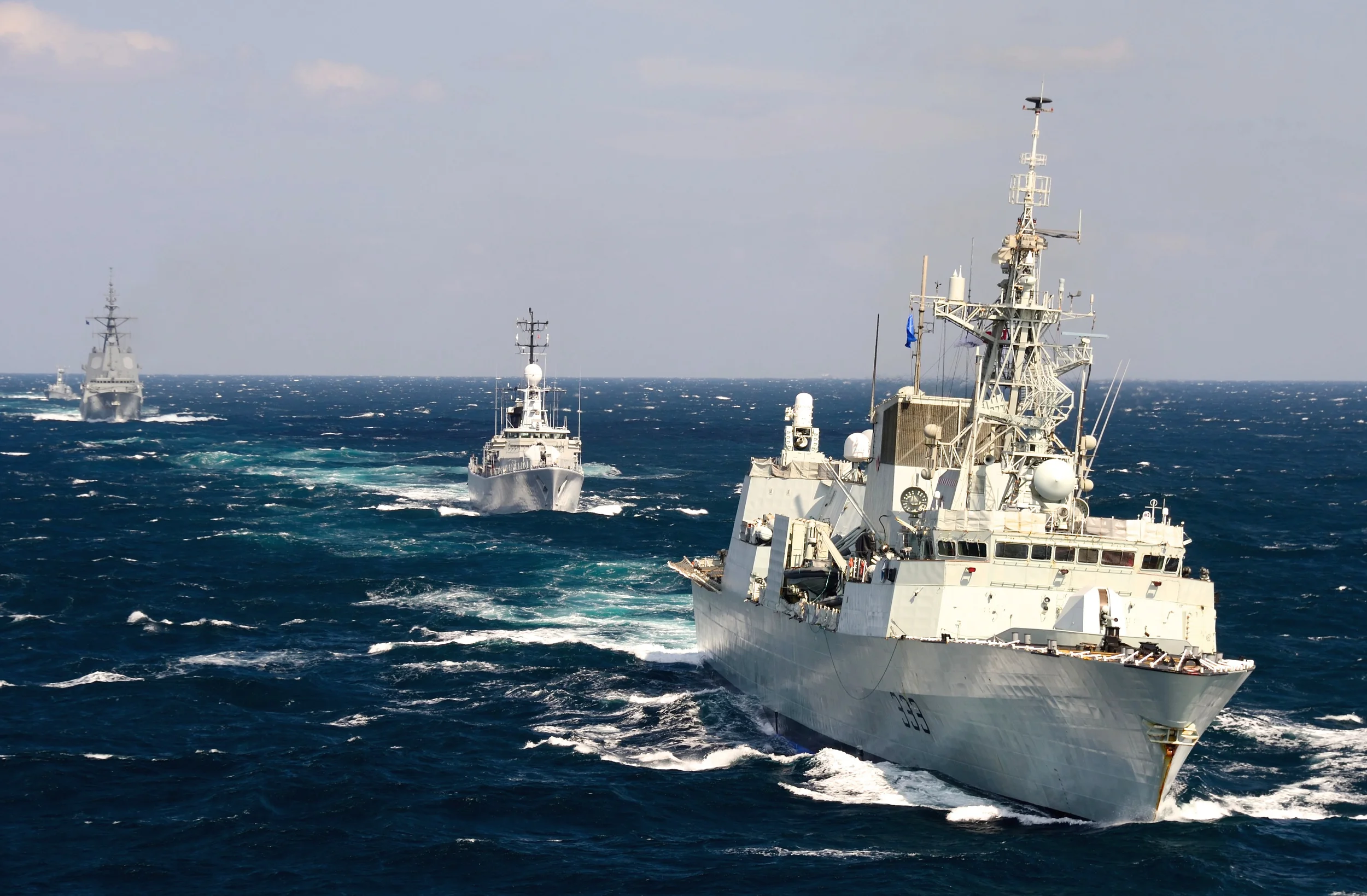 HMCS Toronto, a Halifax-class frigate, leads a fleet of North Atlantic Treaty Organization (NATO) ships through the Black Sea while conducting a training exercise during Operation REASSURANCE in September 2014. Along with the Iroquois-class destroyer ships, the frigates will be replaced under the Canadian Surface Combatant (CSC) program, which will be one of the first procurement projects to be affected by the government's new Defence Procurement Strategy (DPS). (Sgt Matthew McGregor, Combat Camera)