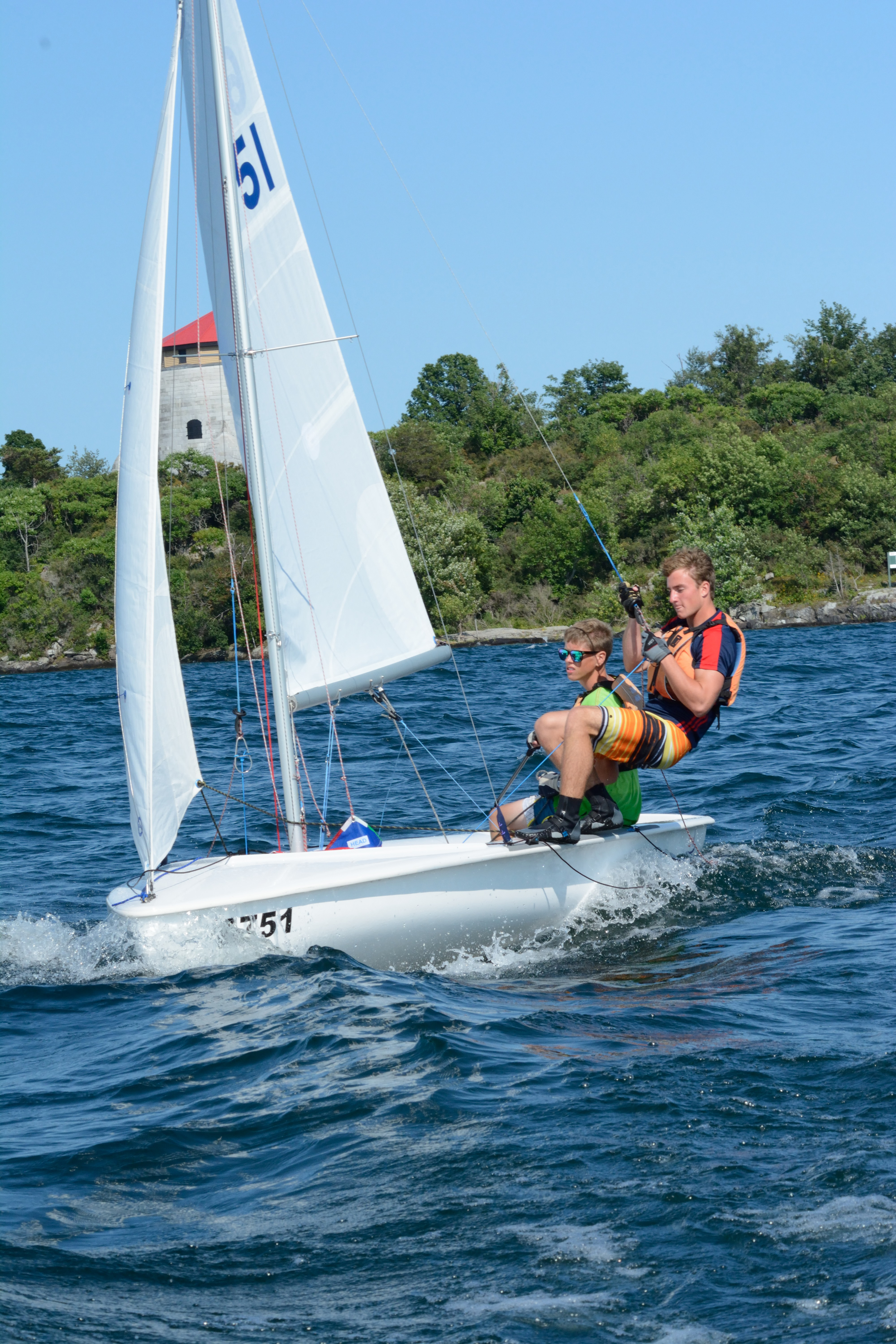 Sea Cadets Steve Dielman and Karl Durtler sail a 420 dingy against the beautiful backdrop of Kingston Harbour and a 19th century British-built Martello tower. For six weeks this summer 20 of Canada's top young cadet sailors came to Kingston to participate in the Advanced Sail Course. (Sgt Kev Parle, DND)