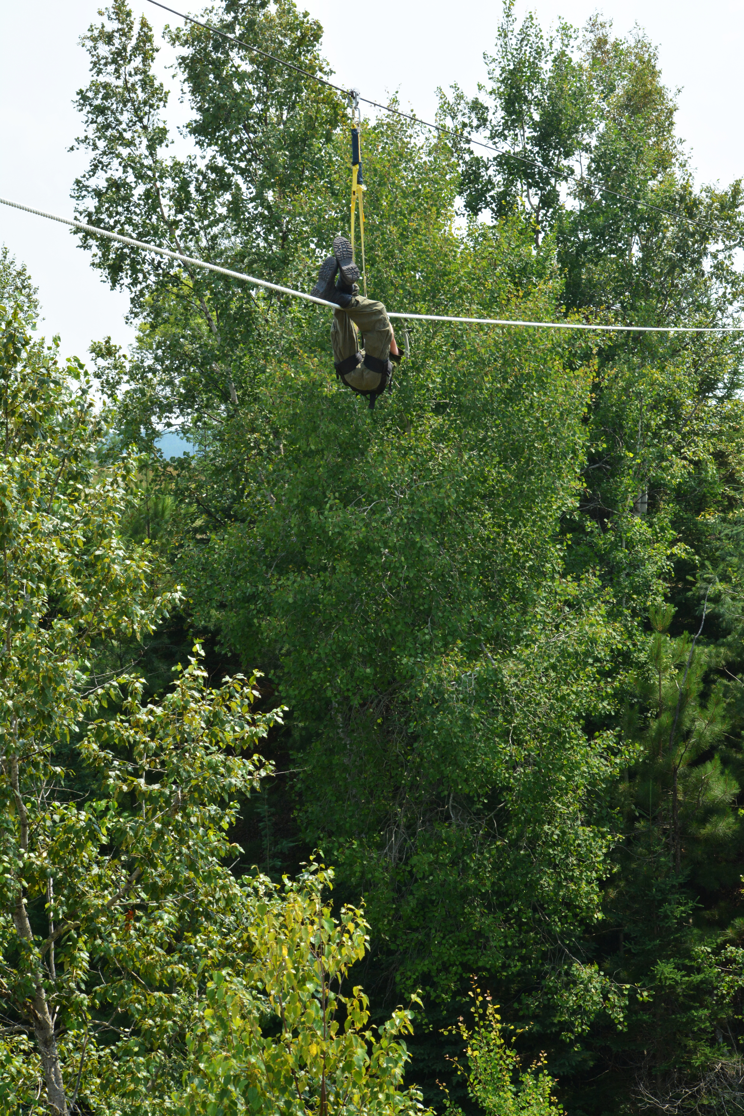 Army Cadet Kevin Mycroft inches his way across a gorge on the single-strand rope bridge as part of the General Training (GT) course at CFB Borden. (Sgt Kevin Parle, DND)