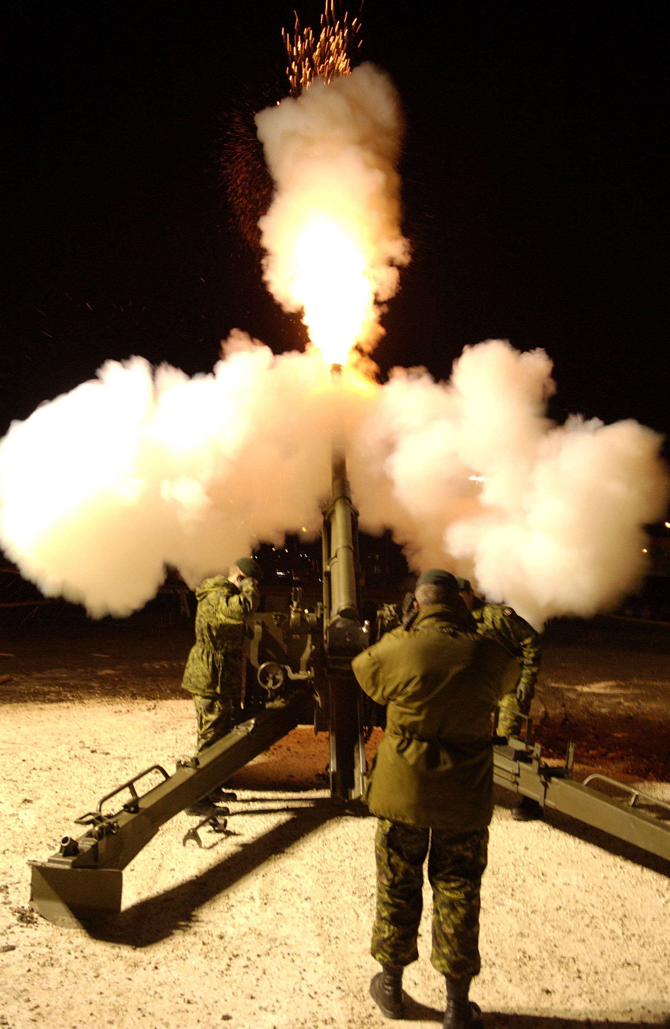 Gunners fire a C3 Howser during a nighttime exercise. This is a close support, field artillery weapon that is mobile, general purpose, light towed, and has the capability to fire extended range munitions up to 18 kilometres. The C3 is manually operated, single-loaded and air-cooled. The C3 is structurally similar to the C1 Howitzer, but is distinguished by its longer 33-calibre barrel and muzzle brake. The gun can fire all standard NATO 105mm Howitzer ammunition. (DND)