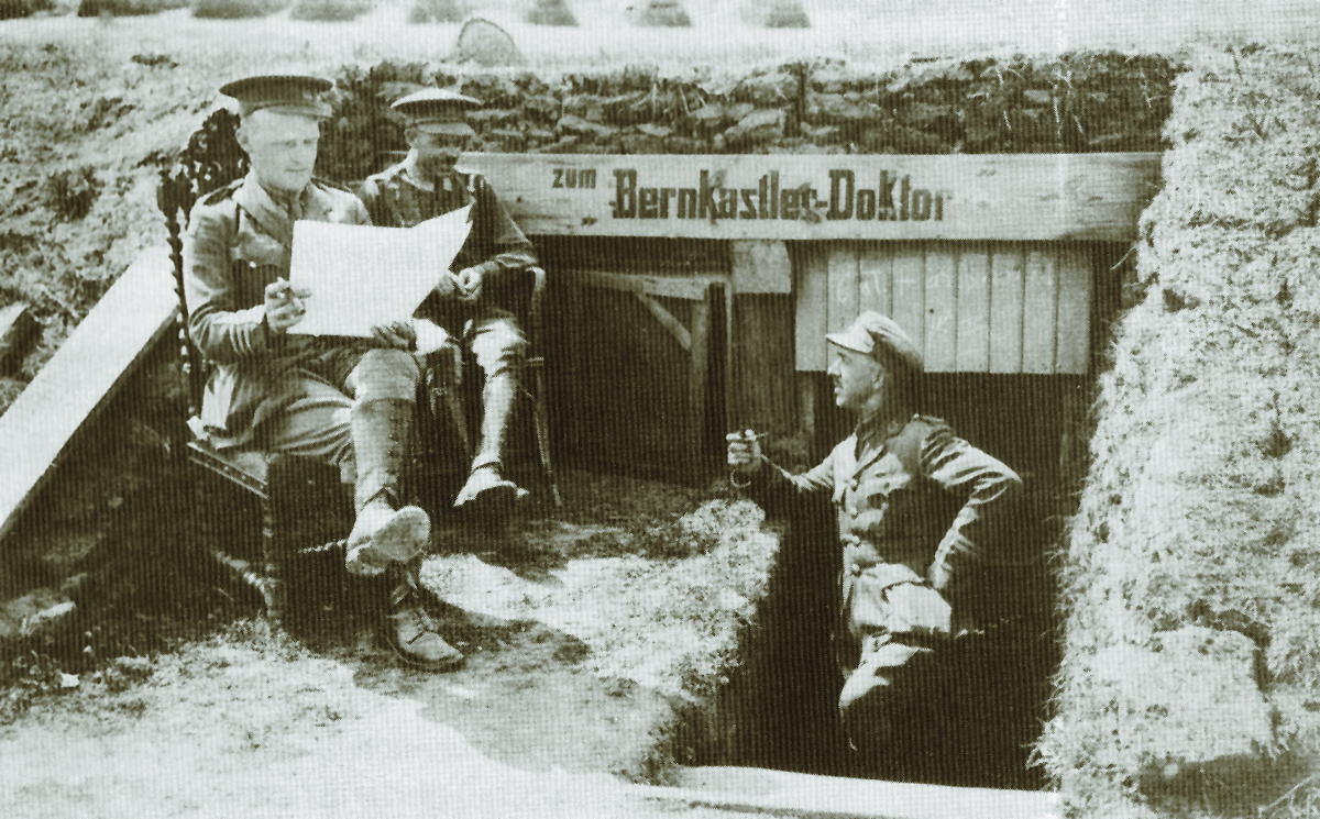 British officers outside a captured and well camouflaged German dressing station during the First World War. During quiet times, officers and enlist3ed men alike took advantage to write letters home, read trench newspapers, and smoke a pipe. (Imperial War Museum)